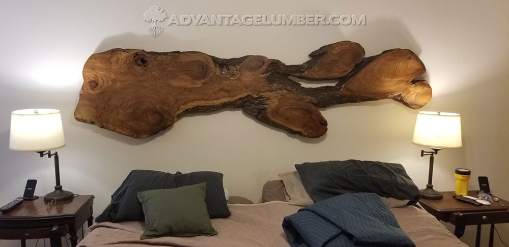 wood slab used as decorative head board and wall art in a bedroom